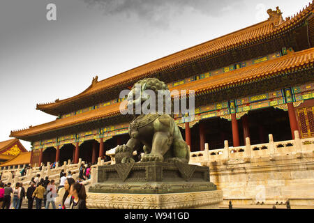 --FILE--touristes passent devant un lion de bronze en face de la porte de l'harmonie suprême à la Cité Interdite à Beijing, Chine, 12 octobre 2013. Le Palac Banque D'Images