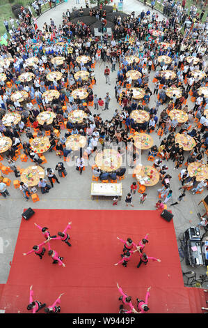 Les personnes âgées locales manger des gâteaux et d'autres aliments autour de tables à la célébration de l'anniversaire dans Dongxidan collective village, ville de Dongcheng, ville de Linhai, ea Banque D'Images