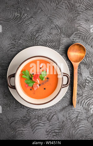Soupe froide espagnole gaspacho de tomates, poivre, ail et fines herbes dans une plaque sombre sur fond noir Vue supérieure avec copyspace. La nourriture végétarienne Banque D'Images