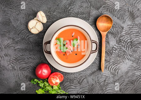 Soupe froide espagnole gaspacho de tomates, poivre, ail et fines herbes dans une plaque sombre sur fond noir Vue supérieure avec copyspace. La nourriture végétarienne Banque D'Images