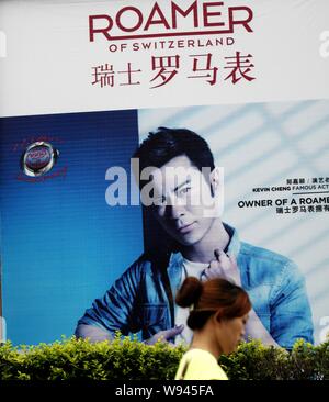 --FILE--un piéton passe devant une publicité de ROAMER à Yichang, Chine centrale de la province du Hubei, 29 mai 2013. La Chine et la Suisse le samedi Banque D'Images