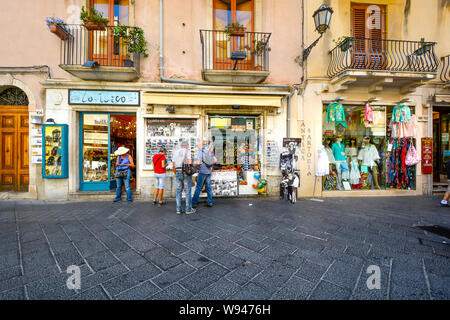 Fenêtre de touristes le long de la boutique Corso Umberto, la rue principale qui traverse l'ancienne zone de villégiature de Taormina Italie, sur l'île méditerranéenne de la Sicile Banque D'Images