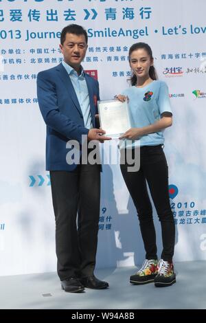 L'acteur chinois Li Yapeng, à gauche, et l'actrice de Hong Kong Angelababy détient un certificat au cours d'un évènement promotionnel pour le sourire Angel Foundation à Pékin Banque D'Images