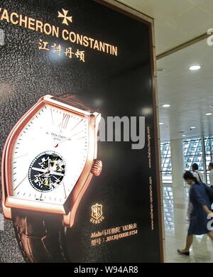 --FILE--passagers à pied passé une publicité pour la marque horlogère Vacheron Constantin à l'Aéroport International de Shanghai Pudong à Shanghai, Chin Banque D'Images