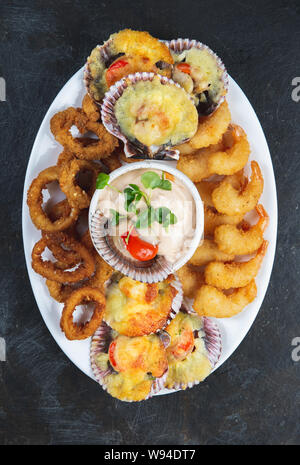 La nourriture péruvienne. Piqueo caliente. Fun pour plateau de fruits de mer crevettes frites, calamars cuits et anneaux de pétoncles avec sauce. Banque D'Images