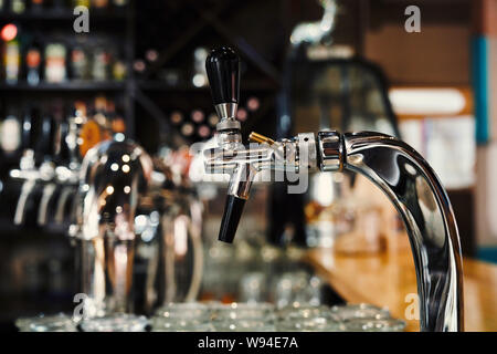 Focus sélectif des robinets modernes dans un pub. Pompes à bière gros plan de l'article dans le café le soir. L'équipement professionnel en brasserie. Concept de la bière, l'ale, l'alcool et de service. Banque D'Images