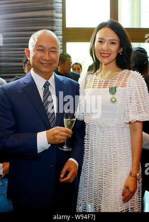 Directeur de Hong Kong John Woo, à gauche, pose avec l'actrice chinoise Zhang Ziyi comme il le félicite pour avoir gagné son Ordre des Arts et des lettres à l'Fren Banque D'Images