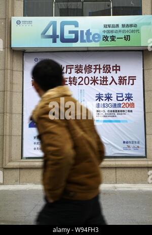 --FILE--un piéton passe devant une publicité de Chine mobiles 4G Network à Wuhan, province de Hubei, Chine centrale 3 février 2013. La Chine est Banque D'Images