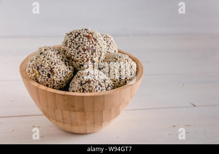 La nourriture végétarienne, des boules d'énergie de noix, dates, les pruneaux, les canneberges et le miel et sésame sur fond blanc Banque D'Images