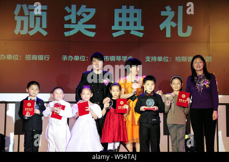 Le pianiste chinois Lang Lang, l'arrière gauche, pose avec de jeunes enfants au cours d'une cérémonie de remise de prix après la finale d'un concours de piano nationaux juvéniles dans Shenz Banque D'Images