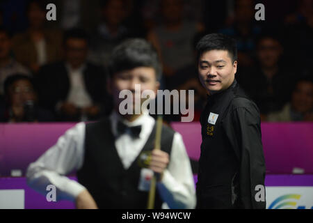 Ding Junhui de Chine, droite, regarde comme il est en concurrence contre Zhou Yuelong de Chine dans leur premier match au cours de l'International World Snooker 2012 Banque D'Images