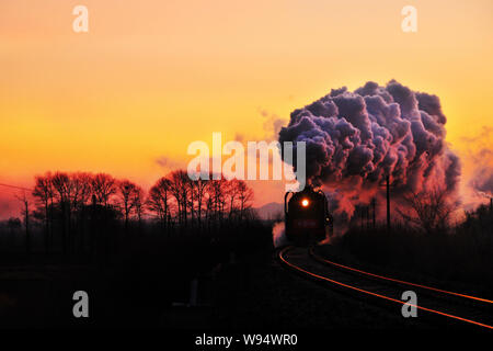Une locomotive à vapeur voyages sur le chemin de fer au coucher du soleil dans le comté de Linxi, ville de Chifeng, Chine du nord Région autonome de Mongolie intérieure, 1 janvier 2012. Ch Banque D'Images