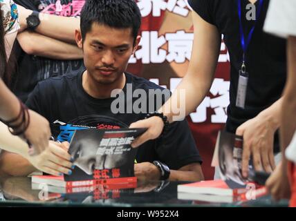 Champion du monde de badminton Chinois Lin Dan signe manuscrit pour les fans lors d'un événement pour promouvoir son autobiographie, jusqu'à la fin du monde, à Beijing Banque D'Images