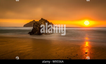 Plage de Holywell à Cornwall pendant le coucher du soleil en été, capturés à l'aide de techniques d'obturation lente. Banque D'Images