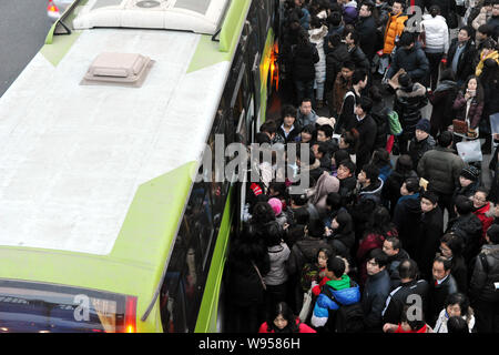 --FILE--une foule de passagers essaient de confiture dans un autobus à Beijing, Chine, 18 février 2011. Chines population urbaine a dépassé le nombre de personnes livi Banque D'Images