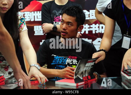 Champion du monde de badminton Chinois Lin Dan signe manuscrit pour les fans lors d'un événement pour promouvoir son autobiographie, jusqu'à la fin du monde, à Beijing Banque D'Images