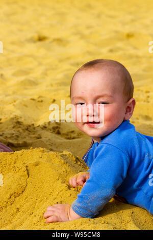 Little baby boy Vincent jouant dans le bac à sable Banque D'Images