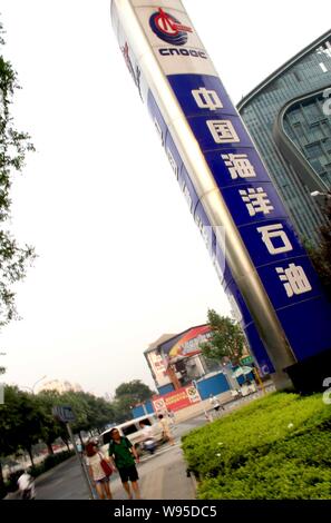 --File--piétons passent devant le siège de la CNOOC (China National Offshore Oil Corporation), à Beijing, Chine, le 6 juillet 2011. Haut offshore oil Banque D'Images
