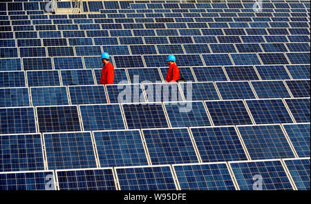 --File--travailleurs chinois vérifier les tableaux de panneaux solaires sur le toit d'un immeuble d'entreprises à Changxing county, province de Zhejiang, Chine de l'est 7 F Banque D'Images