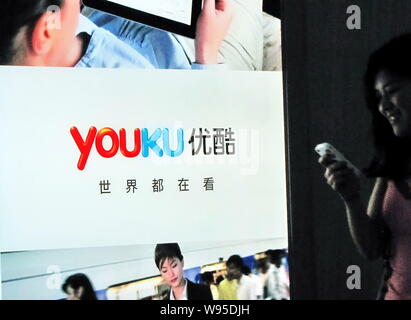 --File--Une femme chinoise utilise son téléphone mobile devant une publicité pour le site de partage de vidéo en ligne Youku.com à Shanghai, Chine, 29 juin 2011. Banque D'Images