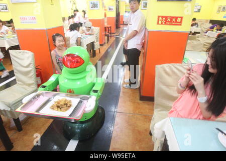 Un robot est vu servir le plat au restaurant du robot dans la ville de Harbin, province de Heilongjiang, Chine du nord-est, le 24 juin 2012. Un restaurant unique, Banque D'Images