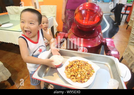 Un robot est vu servir le plat au restaurant du robot dans la ville de Harbin, province de Heilongjiang, Chine du nord-est, le 24 juin 2012. Un restaurant unique, Banque D'Images