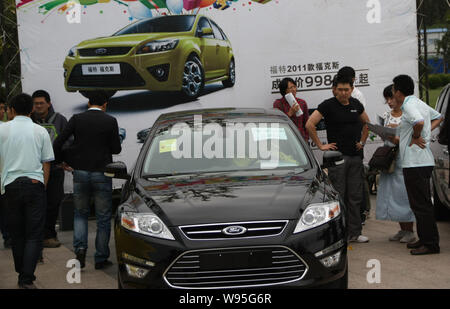 --File--visiteurs regarder une Ford Mondeo lors d'une auto show de la ville de Qingdao, province du Shandong, Chine de l'est 17 septembre 2011. Changan Ford Mazda ha Banque D'Images