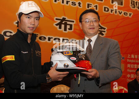 Pilote de F1 chinois Qinghua, ma gauche, montre son casque avec Li Yuyi, directeur du Bureau Municipal des Sports de Shanghai, lors d'une conférence de presse de l'HTS à Shang Banque D'Images