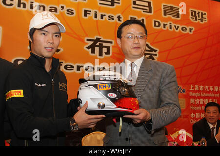 Pilote de F1 chinois Qinghua, ma gauche, montre son casque avec Li Yuyi, directeur du Bureau Municipal des Sports de Shanghai, lors d'une conférence de presse de l'HTS à Shang Banque D'Images