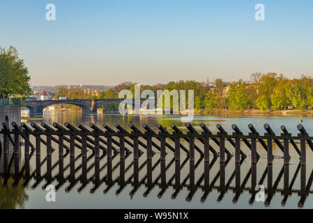 Barrière de pieux en bois debout sur la rivière Vltava et de belles naturelles rivière avec arrière-plan de la plupart des Légions Legií, Bridge, et le parc de l'île. Banque D'Images