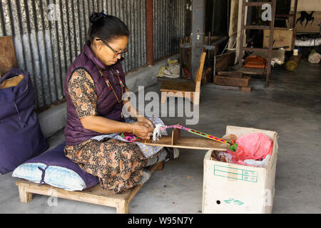 Femme tibétaine à un atelier de tissage de tapis dans Tashi-Ling communauté tibétaine près de Pokhara, Népal Banque D'Images