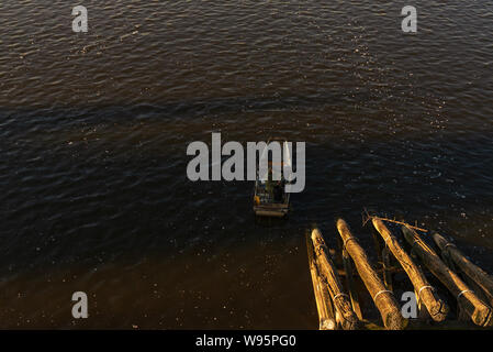 Vue de dessus plus tranquille d'un bateau et l'unique homme la voile et la pêche à l'ombre du pont Charles à Prague, République tchèque. Banque D'Images