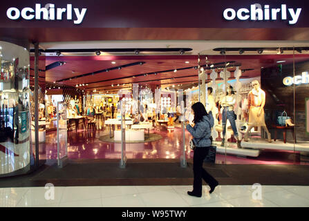 Un piéton passe devant un magasin Ochirly à Shanghai, Chine, le 13 février 2012. Un fonds d'actions privé soutenu par le géant du luxe français LVMH Moet Henness Banque D'Images