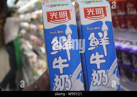 --FILE--un client achète des cartons de lait frais Lait lumineux dans un supermarché dans la ville de Nantong, Chine de l'est de la province de Jiangsu, le 14 septembre 2012. Pour Banque D'Images