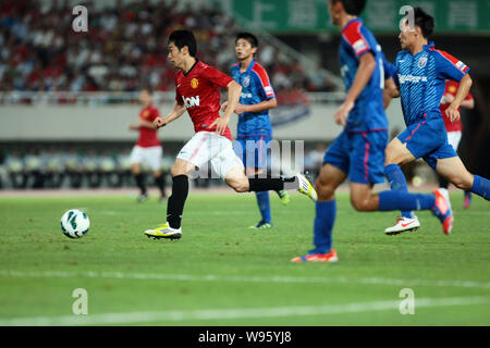 Shinji Kagawa de Manchester United, gauche, dribble contre Shanghai Shenhua dans leur match de football amical au cours de la tournée de pré-saison de Manchester Un Banque D'Images