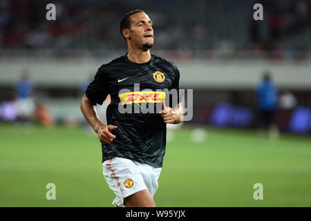 Rio Ferdinand de Manchester United se réchauffe avec coéquipiers avant leur match de football amical contre Shanghai Shenhua durant la tournée d'avant-saison de M Banque D'Images