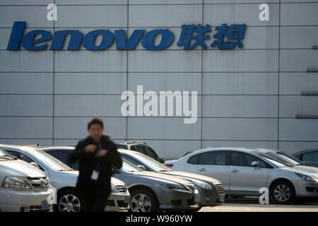 --File -- un membre du personnel passe devant une succursale de Lenovo à Shanghai, Chine, le 12 mars 2012. Yang Yuanqing, PDG et président de Lenovo, a réaffirmé qu'hi Banque D'Images