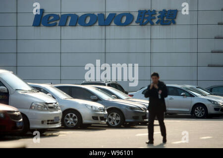 --File -- un membre du personnel passe devant une succursale de Lenovo à Shanghai, Chine, le 12 mars 2012. Yang Yuanqing, PDG et président de Lenovo, a réaffirmé qu'hi Banque D'Images