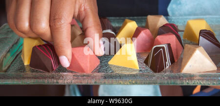 Chocolat pralines vegan colorés en verre sur plateau. Banque D'Images