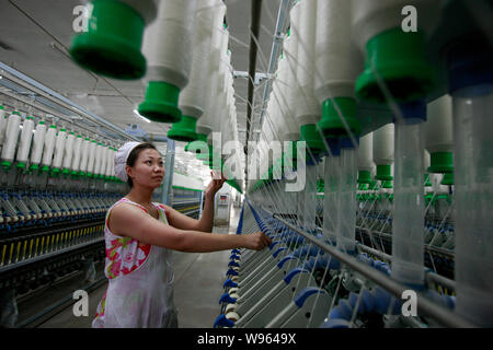 --FILE--une femme travailleur chinois s'occupe de la production de fils à destination de l'Asie du Sud dans une usine de textile à Huaibei ville, East Chines 'anhu Banque D'Images