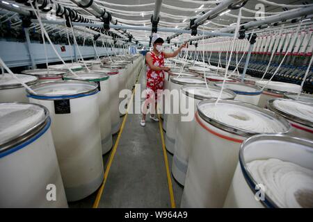 --FILE--une femme travailleur chinois s'occupe de la production de fils à destination de l'Asie du Sud dans une usine de textile à Huaibei ville, East Chines 'anhu Banque D'Images