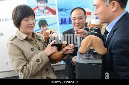 Champion de natation olympique chinoise Ye Shiwen, gauche, sont présentées les chiens âgés au cours d'une cérémonie de livraison à un concessionnaire BMW dans la ville de Hangzhou, Chine de l'Est Banque D'Images