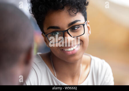 Smiling black girl in verres parler avec tes amis Banque D'Images