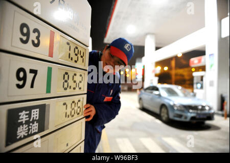 Un travailleur chinois met à jour des prix de l'essence à une station-service dans la ville de Nanchang, province de Jiangxi, Chine de l'est 19 mars 2012. La Chine a soulevé un détail de l'essence Banque D'Images