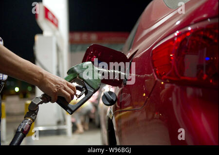 --FILE--un chauffeur ravitaille sa voiture à une station-service dans la ville de Haikou, province de Hainan, Chine du Sud 19 mars 2012. La Chine va réduire le prix de vente au détail de l'essence Banque D'Images