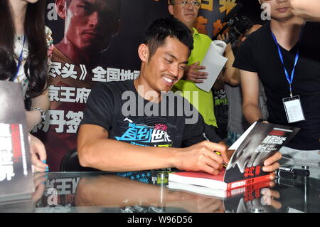 Champion du monde de badminton Chinois Lin Dan signe manuscrit pour les fans lors d'un événement pour promouvoir son autobiographie, jusqu'à la fin du monde, à Beijing Banque D'Images