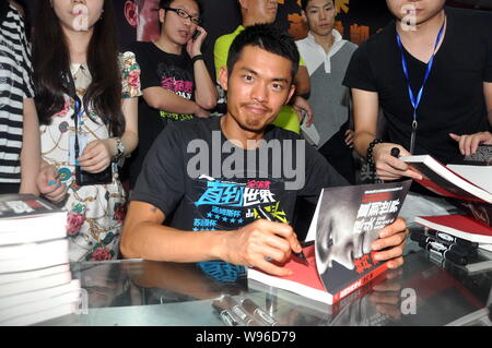 Champion du monde de badminton Chinois Lin Dan signe manuscrit pour les fans lors d'un événement pour promouvoir son autobiographie, jusqu'à la fin du monde, à Beijing Banque D'Images