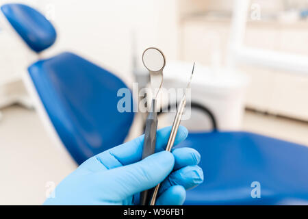 La main du dentiste dans la boîte à gants et de la sonde de l'outil est miroir. . Instrument de la stomatologie dentiste clinique. Travaux dentaires en clinique. Office de Tourisme Banque D'Images