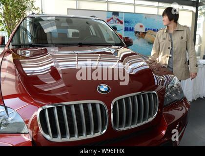 Champion de natation olympique chinoise Ye Shiwen regarde sa BMW X5 au cours d'une cérémonie de livraison à un concessionnaire BMW dans la ville de Hangzhou, Zhejiang Chine de l'Est Banque D'Images