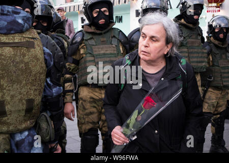 Moscou, Russie - le 10 août 2019, une vieille femme et la rose rouge va de l'avant d'une rangée de policiers en uniforme Banque D'Images